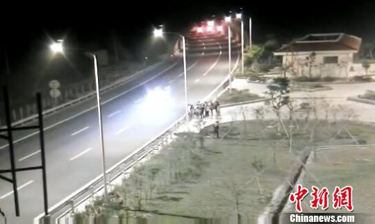 看到車輛經(jīng)過，孩子們便急忙跑到一旁的花圃上?！【焦﹫D　攝