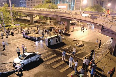 路虎沖下國(guó)貿(mào)橋砸中一輛起亞轎車(chē)，橋上厚達(dá)幾十厘米的水泥護(hù)欄被撞斷，碎石四處散落，數(shù)十群眾在現(xiàn)場(chǎng)圍觀。