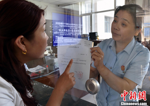 資料圖：2015年5月4日，河北石家莊市橋西區(qū)人民法院立案庭庭長齊燕正在為立案人辦理相關(guān)手續(xù)，完成整個(gè)過程只用了5分鐘。當(dāng)日是立案登記制改革首個(gè)工作日，該院共立案36件，立案率達(dá)到90%。中新社發(fā) 翟羽佳 攝