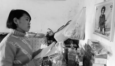 錢仁鳳站在母親遺像前。未能見母親最后一面是她的一大遺憾。