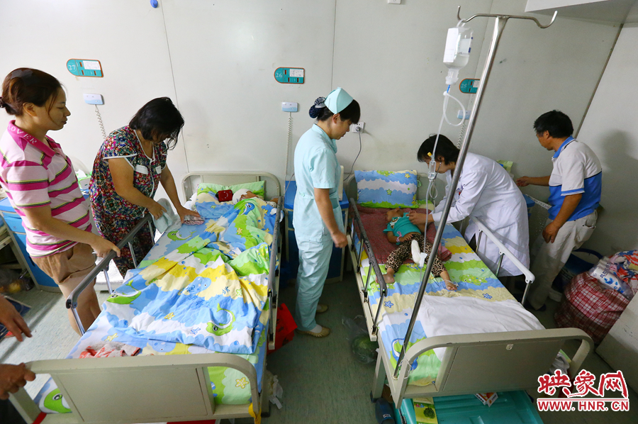 手術(shù)前，畫面右側(cè)的大龍正在接受醫(yī)生的檢查，左側(cè)的小龍還在熟睡。