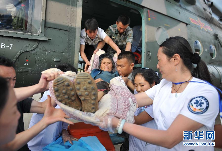 8月5日，醫(yī)護人員將一名通過直升機從震中轉(zhuǎn)運出來的傷員運下飛機。