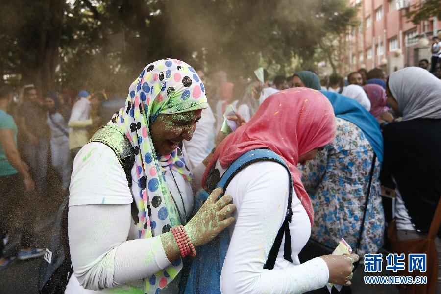 10月16日，在埃及首都開羅，兩名女青年在“彩色跑”活動中躲避人們拋撒的彩色粉末。