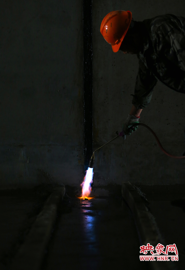 工人師傅用噴槍烘干地面，便于做防水處理