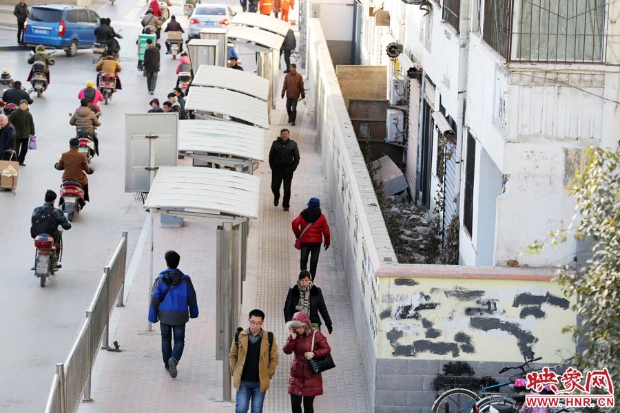 墻內(nèi)扔著垃圾，墻面上涂滿了牛皮癬小廣告，異常顯眼。