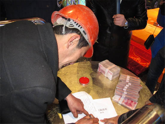 農(nóng)民工在現(xiàn)場領(lǐng)取工資。