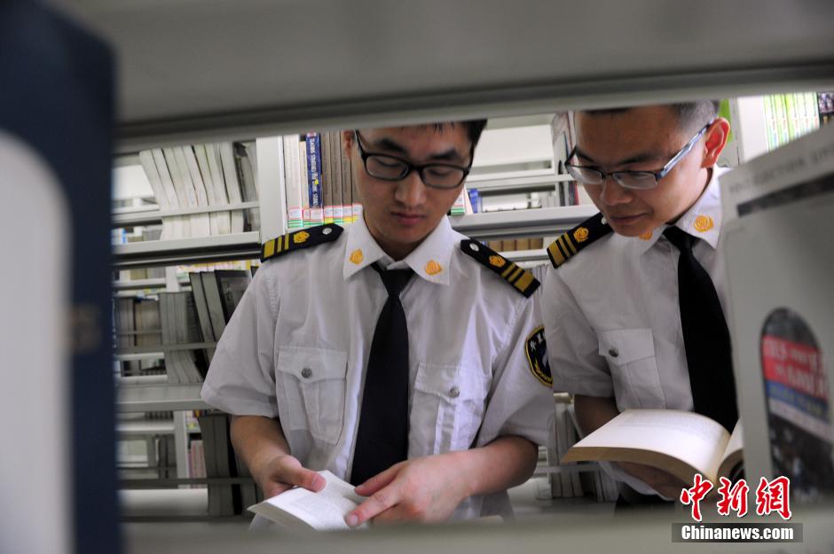 5月8日，武漢輕工大學(xué)圖書館保安吳濤與江力在圖書館交流學(xué)習(xí)。