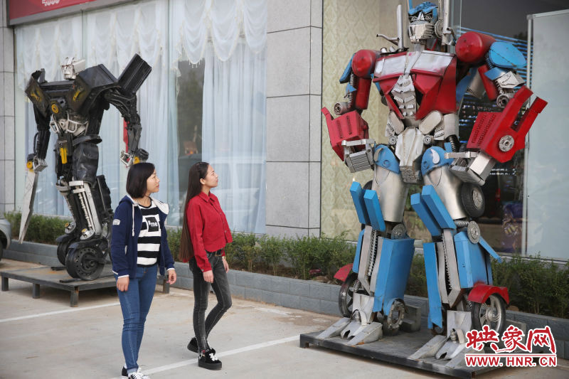 10月14日，市民在參觀河南省平頂山市寶豐縣一家企業(yè)門前的“變形金剛”。