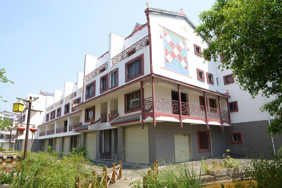 2016年7月26日，村民在廣西來賓市忻城縣隆達山水福城荒廢別墅間放牛。