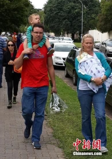 圖為一個(gè)白人家庭，由父母帶著孩子到曼德拉家門(mén)外悼念。中新社發(fā) 宋方燦 攝