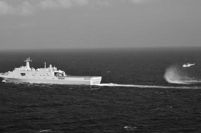 11日，抵達馬航飛機失聯(lián)海區(qū)的海軍井岡山艦與艦載直升機協(xié)同展開立體搜救行動。新華社發(fā)