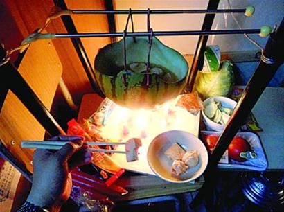 兩張椅子被面對(duì)面疊在一起，穿了兩根線的西瓜皮就懸空在椅腳中間，下面有蠟燭加熱，這就是西瓜火鍋。