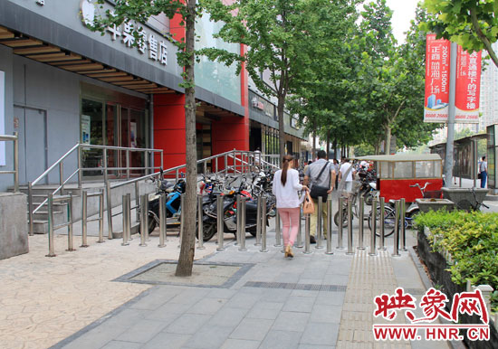 圖中道路左側(cè)的無障礙通道被鋼管隔離,右側(cè)的盲道也被侵占。