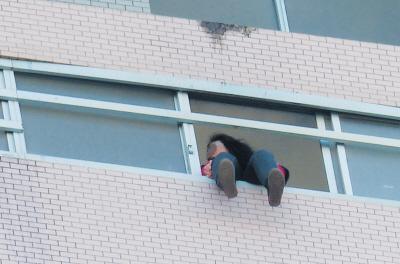 28樓的窗臺(tái)上坐著一名女子，其兩條腿耷拉在室外，不停地?cái)[動(dòng)。