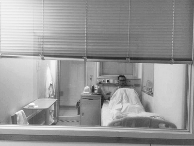 楊杰在醫(yī)院隔離病房中，沖記者揮了揮手。