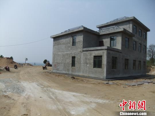 鴨河水庫(kù)庫(kù)區(qū)邊的新建別墅，一面墻上寫(xiě)著“拆”，另一邊在加緊施工。吳揚(yáng)　攝